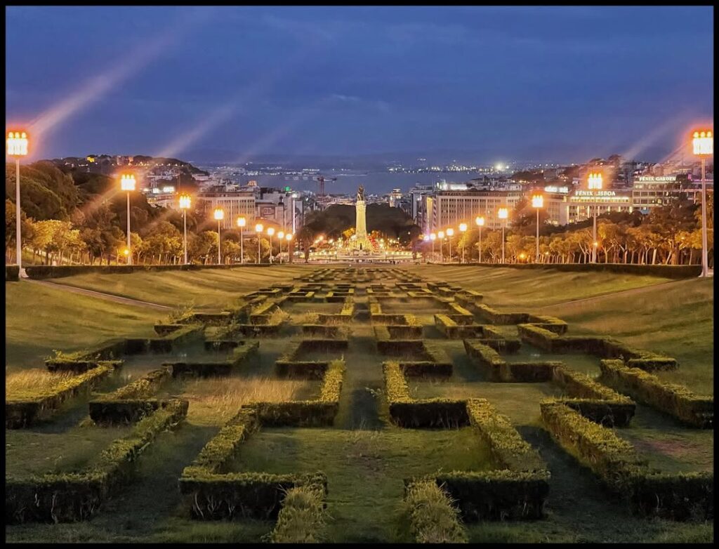 Beautiful view of Lisbon's city park illuminated with streetlights during the evening.