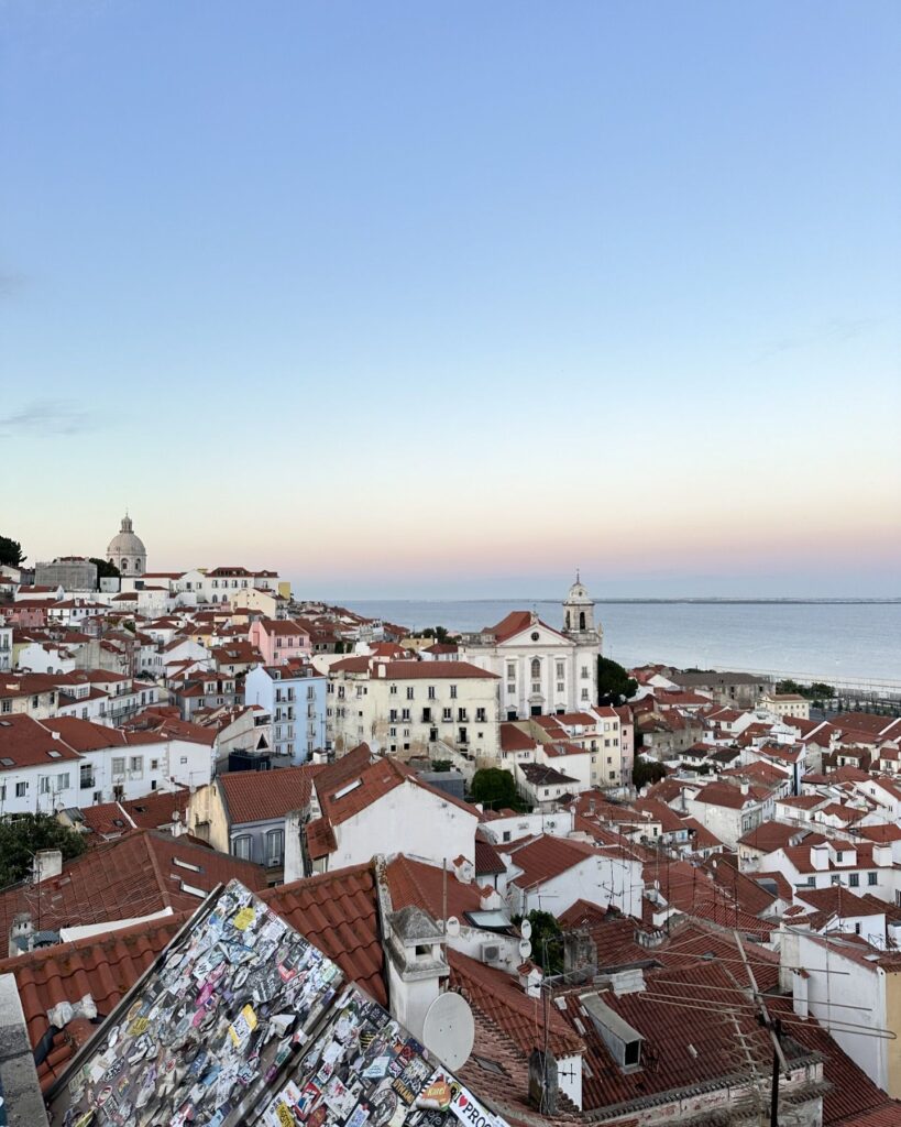 Beautiful panoramic view of Lisbon's historic rooftops with the Atlantic Ocean in the background during spring.