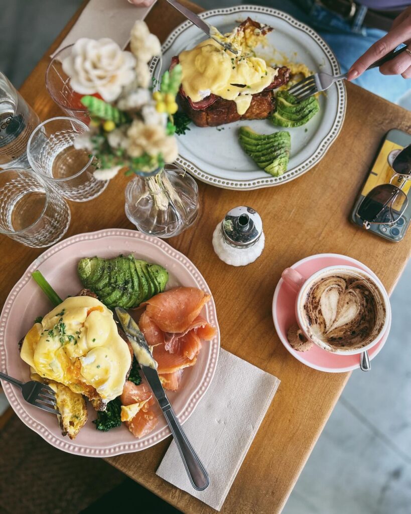 A vibrant breakfast scene in Lisbon featuring eggs Benedict, smoked salmon, fresh vegetables, and a cup of coffee, perfect for enjoying spring mornings in the city.
