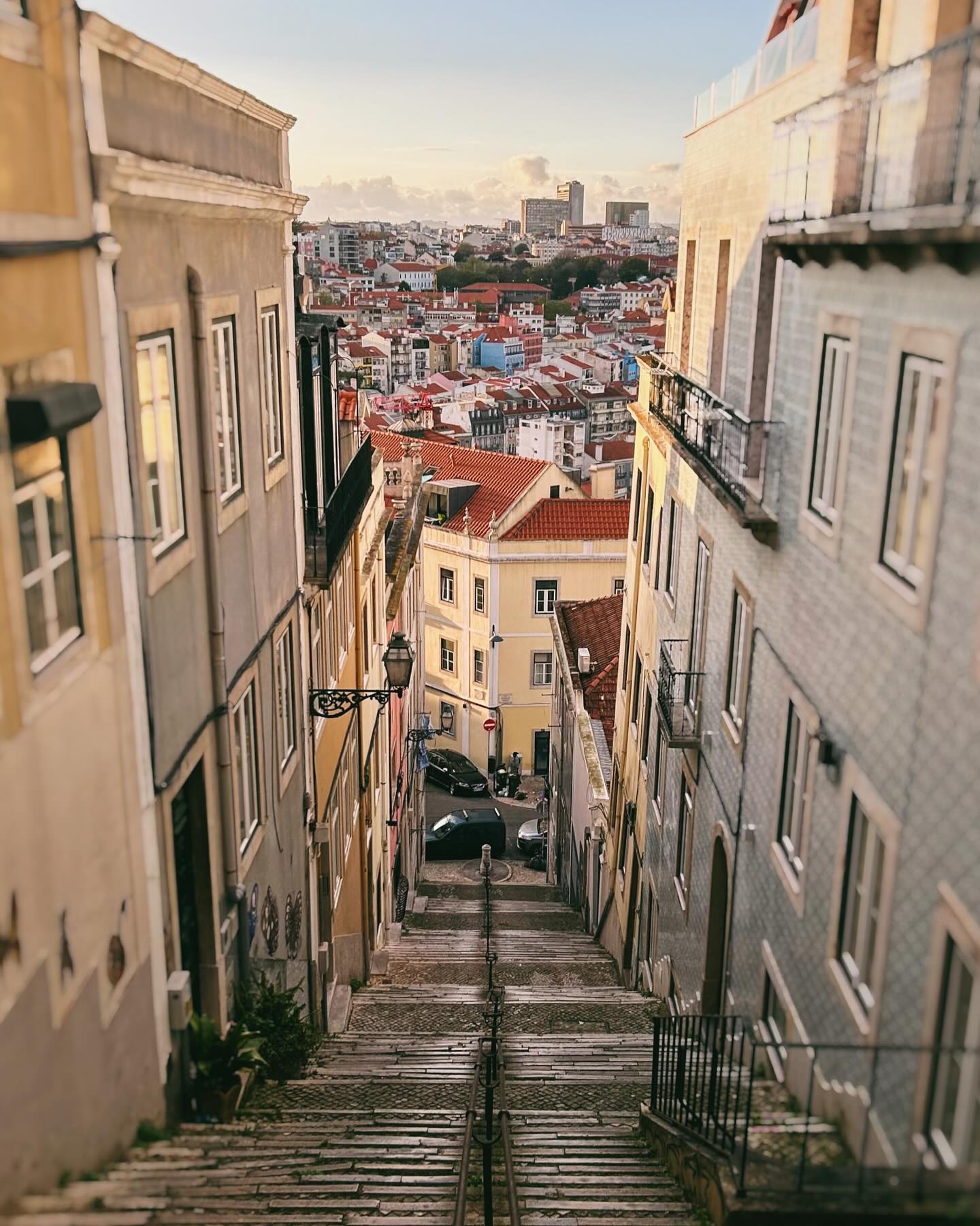 Lisbon in March: 10 Things To Do (Spring is Here) 1 Scenic view of Lisbon from the Bica funicular, showcasing colorful rooftops and historic architecture in the vibrant cityscape.