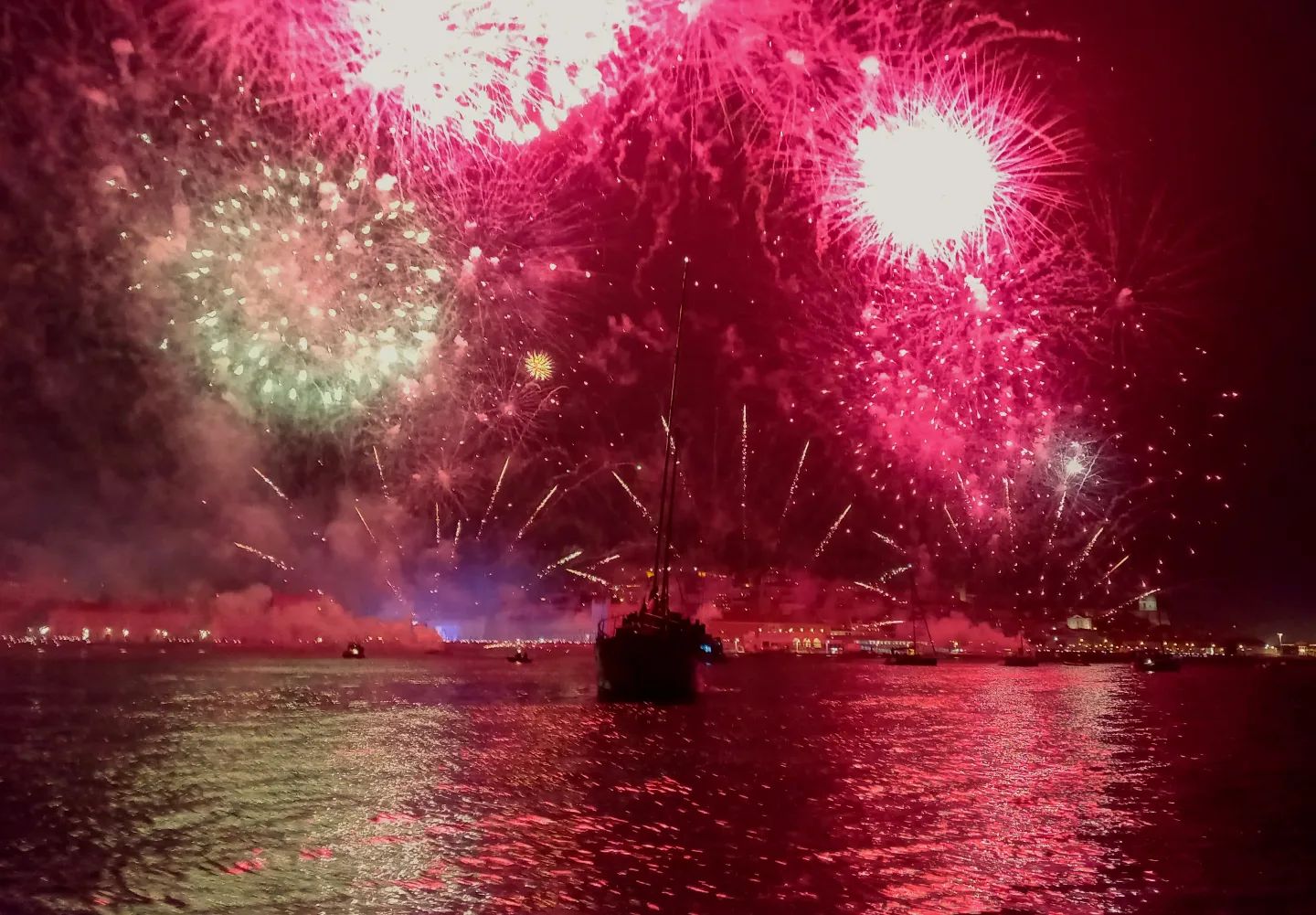 New Year in Lisbon 2026 (Where to See the Fireworks) 7 Spectacular fireworks display over Lisbon harbor celebrating New Year 2026, with vibrant colors illuminating the night sky and reflecting on the water.