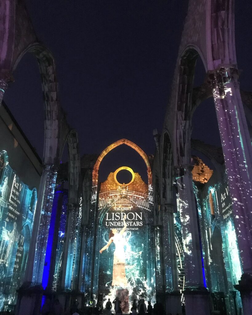 Lisbon in May - Less Crowded? (Perfect Time To Visit) 4 Lisbon under stars light show with vibrant projections on historic architecture, perfect for visiting in May when the city is less crowded and ideal for exploring cultural attractions.