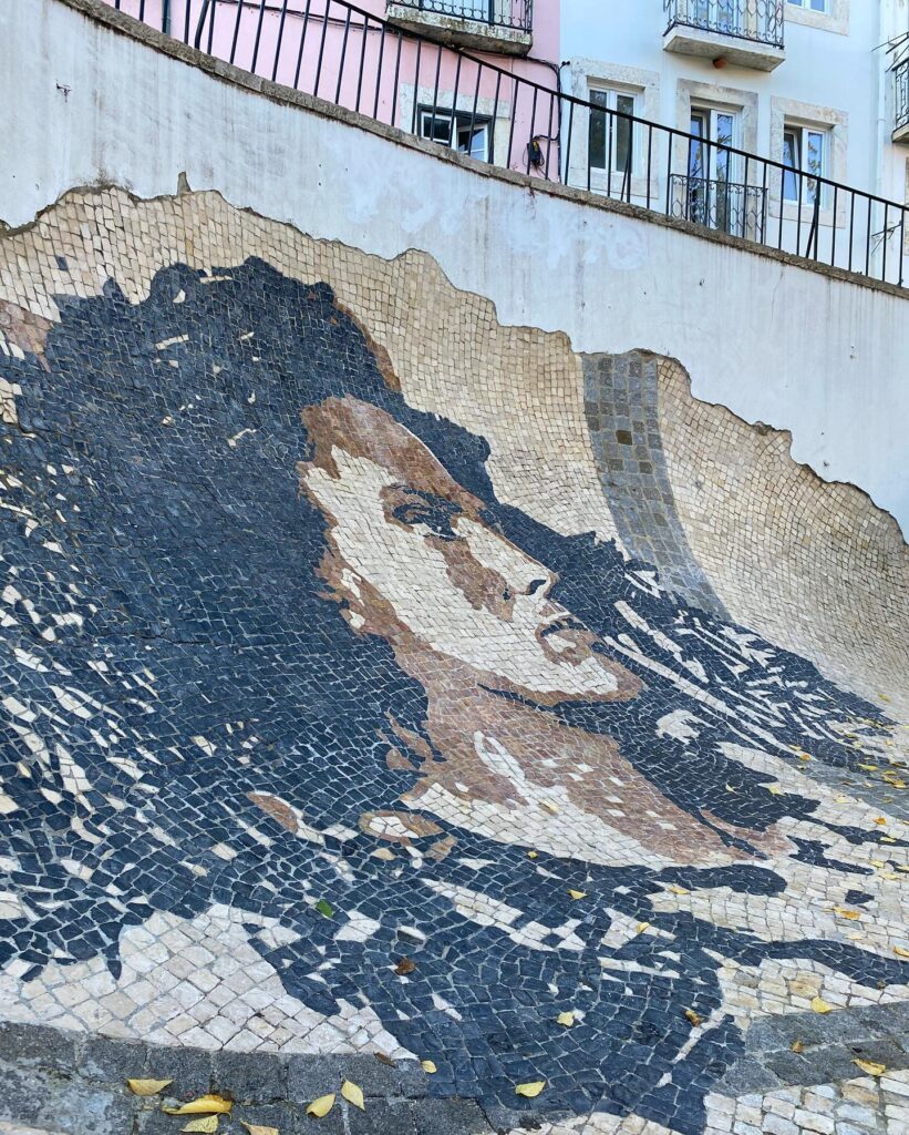 Vibrant mosaic mural of a woman's face in Alfama, Lisbon, showcasing traditional tile art and local culture.