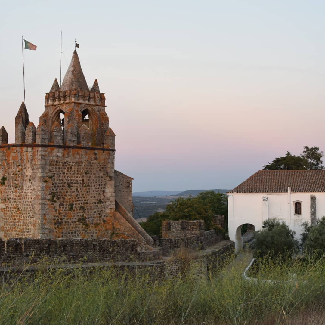 21 Amazing Castles in Lisbon and Its Surroundings 19 Rustic medieval castle with stone walls and turrets in a scenic countryside setting at sunset, capturing historic architecture and peaceful landscape views in Lisbon, Portugal.