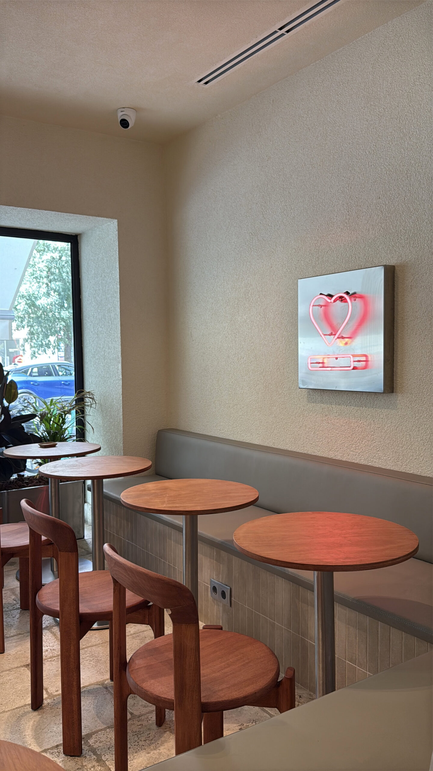6 Best Cafés in Lisbon: Where I Go for Coffee, Work & Relaxing 8 Bright and inviting coffee shop corner in Lisbon with wooden tables and chairs, natural light from the window, perfect for enjoying a cup of coffee in a relaxed atmosphere.