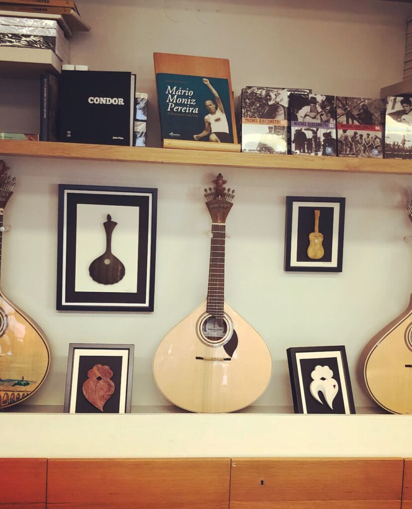 Elegant guitar artwork with framed illustrations in a cozy Lisbon shop.
