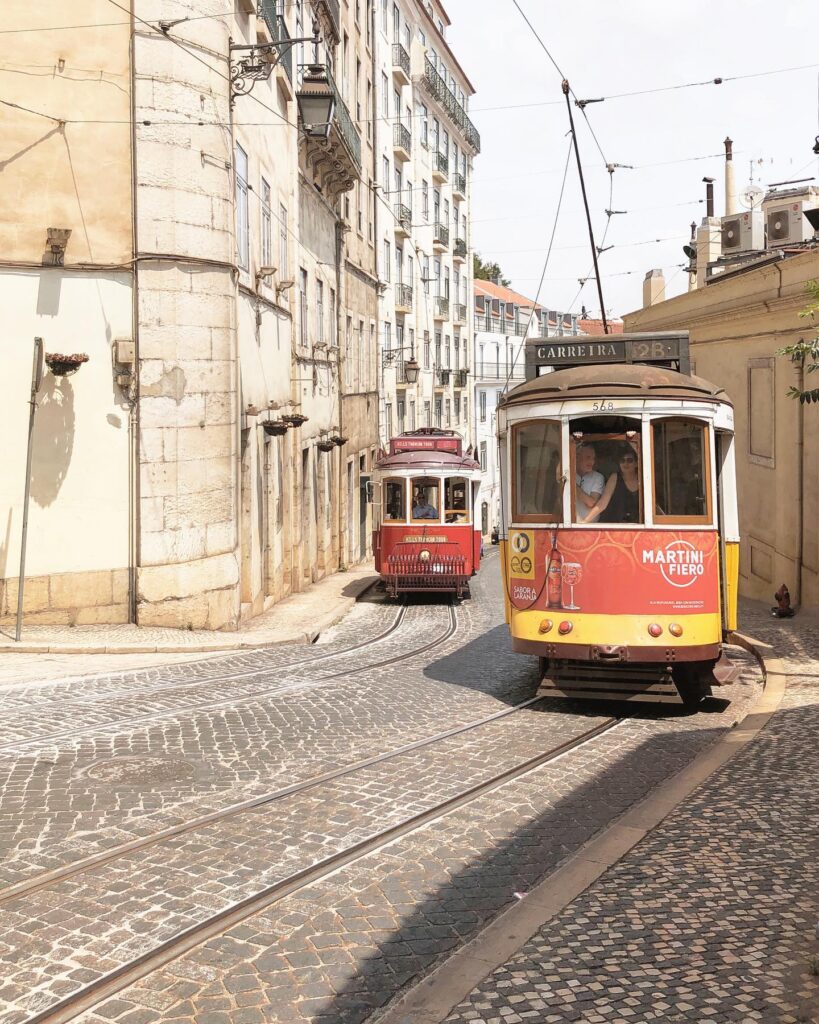 Vintage Lisbon Tram 28 navigating through narrow cobblestone streets in the historic Alfama district, capturing the essence of Portugal's iconic tram experience.