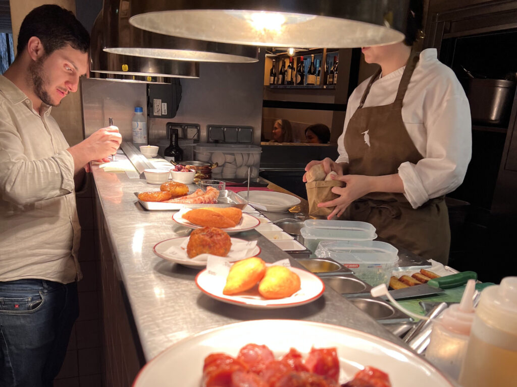 Succulent chorizo sausages served at a bustling Lisbon restaurant, showcasing authentic Portuguese cuisine in a cozy, vibrant atmosphere perfect for food lovers exploring Lisbon’s local flavors.