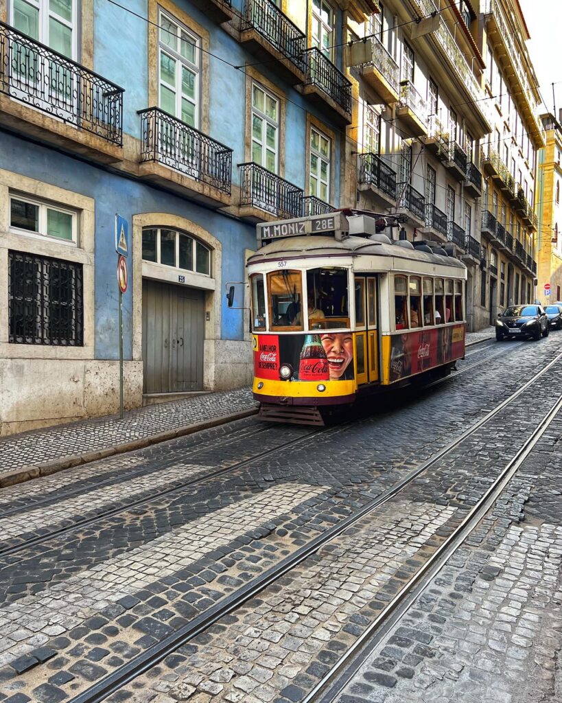 Historic Lisbon Tram 28 navigating through colorful streets.