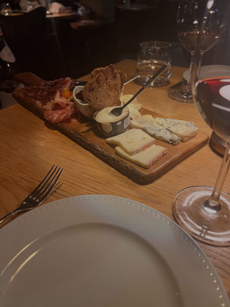 Lisbon Food Guide: What to Eat + Where to Eat (Local Tips + Map) 8 Delicious Portuguese cheese and charcuterie platter with wine and bread at a cozy Lisbon restaurant, showcasing authentic flavors and local delicacies in LisbonVibes.